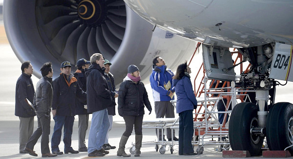 US officials, center, inspect a All Nippon Airways jet. Photo: AP / Kyoto News