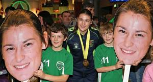COOL HEADS: Katie Taylor is greeted by brothers Gearoid and Oisin Murphy from Greystones, Co Wicklow, following her arrival at Dublin Airport after winning her fifth world title. Picture: Colin Keegan 