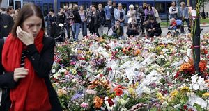 Mourners gather near to the massive field of flowers in front of the Oslo Cathedral in Oslo, Norway, today. Pic: AP