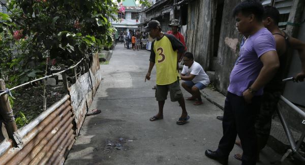 Neighbours look at the spot where a gunman was killed by responding police following a shooting rampage south of Manila.Picture: AP