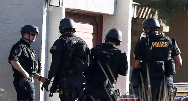 A SWAT team prepare to enter the home of a suspected gunman.