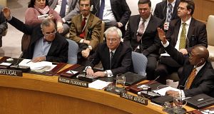 Portuguese representative Jose Filipe Moraes Cabral, left, and South African representative Baso Sangqu, right, glance at Russian representative Vitaly Churkin, center, as they vote today.