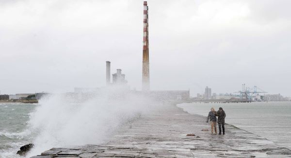 People brave the elements and ignore the weather warning to stay away from exposed coastal areas, as they walk out to Poolbeg lighthouse in Dublin this afternoon. Picture: Laura Hutton, Photocall